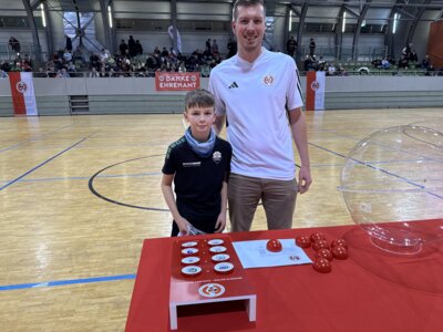 Losfee Timmy und FLB-Mitarbeiter Steven Mund an der Loskugel in der Lausitz-Arena in Cottbus.