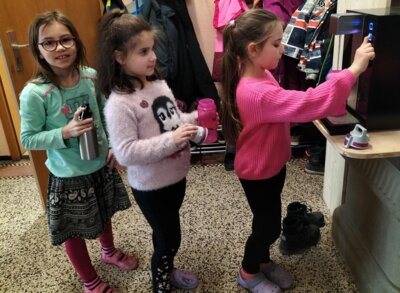 Kinder füllen sich ihre Trinkflaschen am Wasserspender (Bild vergrößern)