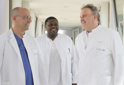 BUZ v. l. n. r.: Dr. med. Peter Flies, ärztlicher Direktor und Chefarzt Innere Medizin I/Kardiologie, Hermann Sighomnou Guemto (Sektionsleiter Innere Medizin II) und Dr. med. Christof Reiner, Chefarzt Innere Medizin II / Gastroenterologie und Pneumologie