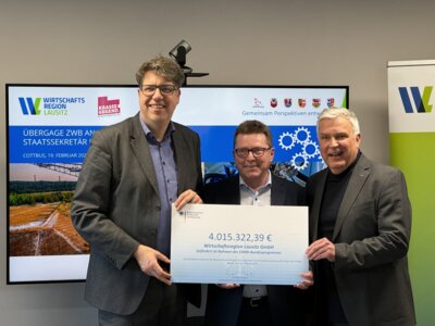 Michael Kellner, Parlamentarischer Staatssekretär im Bundesministerium für Wirtschaft und Klimaschutz, übergab feierlich den symbolischen Scheck an Heiko Jahn, Geschäftsführer der Wirtschaftsregion Lausitz, und Dr. Klaus Freytag, Lausitz-Beauftragter des Ministerpräsidenten. Bildautor: WRL/ Arnold