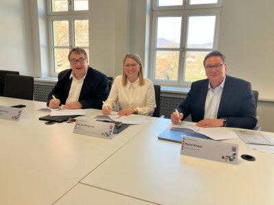 Regierungspräsident Mark Weinmeister, Landrätin Nicole Rathgeber und Horst Kraus, Geschäftsführer Mittelpunkt Personal GmbH (v.l.n.r.) unterzeichnen die gemeinsame Absichtserklärung zum Projekt zur Anwerbung von Pflegekräften im Ausland. (Bild vergrößern)
