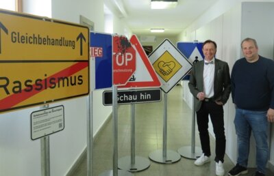 ürgermeister Bernhard Uhl (links) mit Bauamtsmitarbeiter Tobias Riedel (rechts) vor den „Verkehrsschildern der Gerechtigkeit“ / Fotograf: Markt Zusmarshausen (Bild vergr&ouml;&szlig;ern)