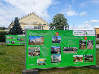 An großen Bauzaunbannern können sich interessierte Bürgerinnen und Bürger vor dem Kulturhaus über aktuelle und vergangene Bauprojekte informieren. Foto: Stadt Pritzwalk (Bild vergr&ouml;&szlig;ern)