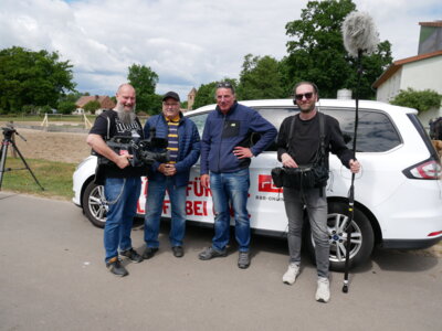 Foto: Rolandstadt Perleberg/Renè Hill | Ortsvorsteher Armin Schwarz (2.v.l.) ist mit dem rbb-Team um Reporter Frank Overhof (2.v.r.) in Quitzow unterwegs.