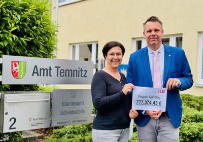 Fachamtsleiterin Kinder und Jugend, Katrin Pein und Amtsdirektor Thomas Kresse mit der Summe des Zuwendungsbescheides zum Projekt Ganztag der Schule und Hort Wildberg (Bild vergrößern)