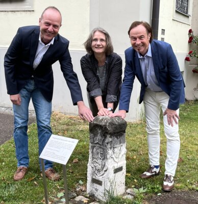 Der Grenzstein von Wollbach aus dem Jahr 1609 ist öffentlich zugänglich und kann vor dem Augsburger staatlichen Vermessungsamt bewundert werden. Amtsleiter Thomas Gruber zeigte den Grenzstein Archivarin Angela Schlenkrich und Bürgermeister Bernhard Uhl aus Zusmarshausen. / Fotograf: Bernhard Weißenböck (Bild vergrößern)