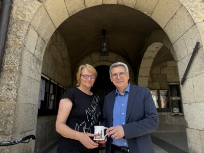 Jeannette Küther vom KSTW überreicht Bürgermeister Dr. Oliver Hermann den Kaffee-Pott mit Rathausmotiv | Foto: F. Lenz (Bild vergrößern)