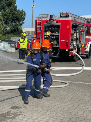 2 Kinder üben mit der Technik der Feuerwehr