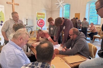 Teilnehmerinnen der Beteiligungswerkstatt bei der Bearbeitung einer von 3 Fragestellungen in der Kirche Walsleben (Bild vergr&ouml;&szlig;ern)