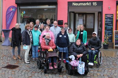 Vor dem Büro "MittenDrin" stehen der Bürgermeister von Auerbach, Jens Scharff, die Koordinatorinnen und einige Mitarbeitenende der Stadt sowie weitere Beteiligte am Projekt. Sie lächeln in die Kamera. (Bild vergr&ouml;&szlig;ern)