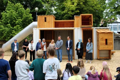 Sie ist viel mehr als nur ein einfacher Container - die Kinder der Pestalozzi-Grundschule in Kulmbach freuen sich über eine sogenannte KuKuk-Box. Der innovative Spielcontainer einer Stuttgarter Firma bietet den Kindern mit einer Rutsche und einer Kletterwand jede Menge Raum zum Spielen, Ausprobieren und Klettern. Die Herstellerfirma hat der Stadt Kulmbach eine solche KuKuk-Box für ein Jahr kostenfrei überlassen. Darüber freuten sich bei der Eröffnung nicht nur die Schulkinder, sondern auch Oberbürgermeister Ingo Lehmann, Schulleiterin Sandra Stenglein, Vertreter der „Initiative liebenswertes Kulmbach“, des Elternbeirats und der städtischen Hochbauabteilung sowie Bernwart Engelen von der Herstellerfirma der KuKukbox (Bildquelle: Stadt Kulmbach). (Bild vergr&ouml;&szlig;ern)