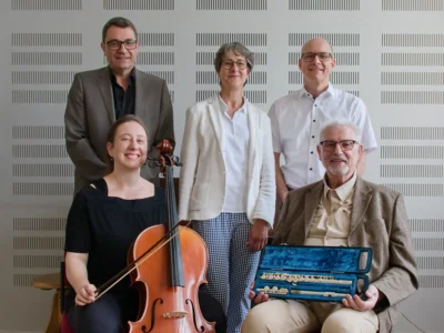 Aus traurigem Anlass entstanden berührende Gesten zum Wohle der Musikschule Kulmbach: Walter Schleicher (1. Reihe, rechts) überreichte an die Musikschule mit Lehrkraft Ulrike M. Gossel (1. Reihe, links), Kultur- und Musikschulleiter Harald Streit (2. Reihe, links), Förderverbandsvorsitzende Anja Gimpel-Henning (Mitte) und Beisitzer Christian Recker (2. Reihe, rechts) gleich zwei Instrumente. Zum einen ein neues Violoncello und zum anderen eine Flöte. Letztere stammt aus dem Nachlass von Walter Schleichers verstorbener Schwester. Die Anschaffung des Violoncellos wurde dank einer Geldspende des ehemaligen Musikschulleiters möglich und hat ebenfalls einen sehr persönlichen und traurigen Hintergrund. Walter Schleicher hatte nach dem Tod seiner Ehefrau im vergangenen Herbst statt um Blumenspenden und Geldspenden für die Musikschule Kulmbach gebeten (Bildquelle: Harald Streit, Musikschule Kulmbach). (Bild vergr&ouml;&szlig;ern)
