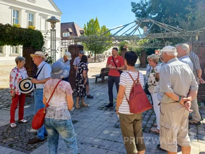 Lars Schladitz (im roten Shirt) bot den Besucherinnen und Besuchern – hier am Rathaus – Informatives rund um die Innenstadt. Foto: Stadt Pritzwalk (Bild vergr&ouml;&szlig;ern)
