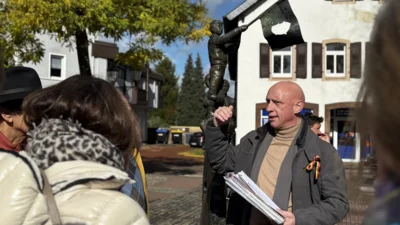 Klaus Friedrich erklärt am Homburger Freiheitsbrunnen dessen Symbolik zum Vormärz und Mauerfall 1989 und die damit verbundenen Bezüge nach Amerika. Foto: Beate Ruffing
