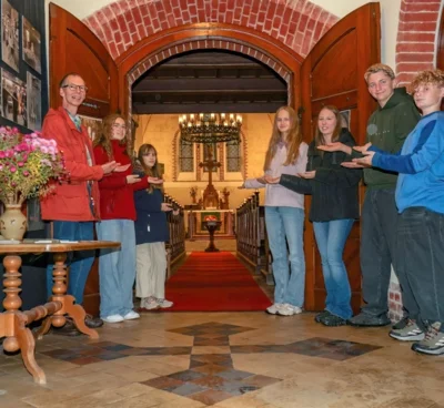 Bernhard Hasse mit Konfirmandinnen und Konfirmanden vor der offenen Kirche Schildow (Bild vergr&ouml;&szlig;ern)
