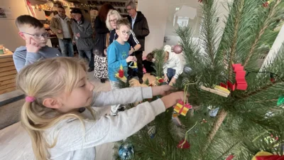 Kinder der Sassnitzer Grundschule gestalten mit unserem Bürgermeister gemeinsam den Tierpark-Weihnachtsbaum. (Bild vergr&ouml;&szlig;ern)