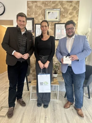 Erster Bürgermeister Nicolas Lahovnik (links) gratuliert gemeinsam mit Gewerbeforumsvorsitzenden Aaron Grimm (rechts) Sema Cakir zur Selbstständigkeit.