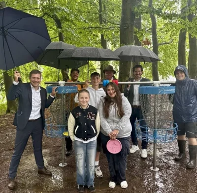 Erster Bürgermeister Nicolas Lahovnik (links) eröffnete gemeinsam mit den Mitgliedern der Jugendvertretung Mathilda Brand, Felix Baier und Anna Kokidko (vorne), sowie Jannick Wetterich von der WOD GmbH, Stadtförster Hubert Steinberger sowie Geschäftsleitendem Beamten Daniel Wolf (hinten) und Felix Bierig von der WOD GmbH den neuen Discgolf-Parcours im Wunsiedler Bürgerpark.