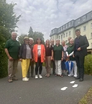 Erster Bürgermeister Nicolas Lahovnik (rechts) freut sich mit Generationenbürgermeisterin Carolin Kammerer (5. v. l.), Vorsitzender der Seniorenvertretung Martina Kerschbaum (2. v. l.), Leiterin des Mehrgenerationenhauses Heike Syma (4. v. l.) und den Mitgliedern der Seniorenvertretung über den neuen Barrierefreien Weg.