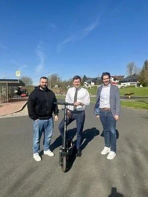 Erster Bürgermeister Nicolas Lahovnik (Mitte) freut sich gemeinsam mit Geschäftsleiter Daniel Wolf (rechts) und Ridvan Yücel von Y Mobility GmbH über das neue E-Scooter Pilotprojekt in Wunsiedel.