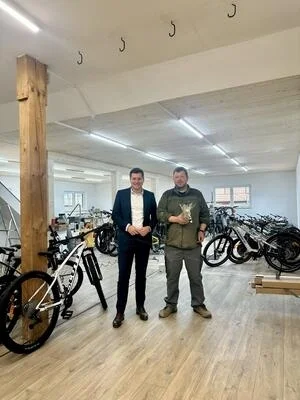 Erster Bürgermeister Nicolas Lahovnik (links) und Christian Schneider, Geschäftsführer von Zweirad Schneider freuen sich über die Erweiterung des Geschäfts.