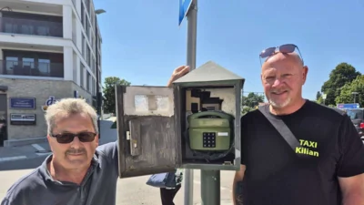Bald bimmelt es wieder: die Taxifahrer Erhard Sagunsky (l.) und Michael Kilian mit dem grünen Tastentelefon am Gautinger Bahnhof. Aktuell funktioniert es nicht, doch bald soll man dort wieder anrufen können. © Ufertinger (Bild vergr&ouml;&szlig;ern)
