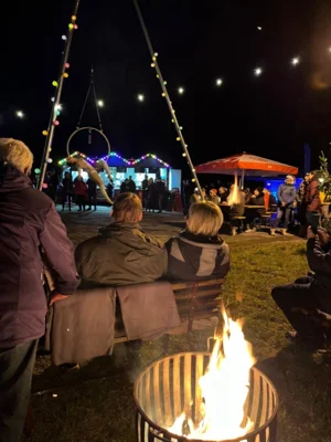 Weihnachtsmarktbesucher genießen die Show von „Twin Goddess“ mit ihrer Höhenakrobatik