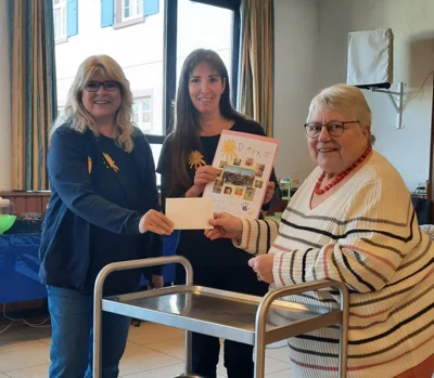 Foto: Auf dem Foto stehen links Petra Doering und daneben Heike Klemm. Beide vertreten den Verein Wir DABEI! Rechts daneben steht Frau Dr. Fettel, die Frau Doering den Umschlag mit der Spende überreicht. Heike Klemm hält die Dankesurkunde für den katholischen Frauenbund Mörlenbach in den Händen. Foto zur Meldung: Satt essen für den guten Zweck