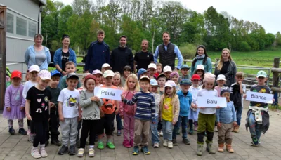 Zum gemeinsamen Foto versammelten sich Kita-Kinder mit ihren Namenschilden. Im Hintergrund Erzieherinnen, die Abordnung der Gemeinde  und Landwirt Manuel Fischbach (5. v. l.). (Bild vergr&ouml;&szlig;ern)