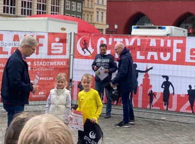 Unser Jannis Timm (gelbes Hemd) durfte zur Siegerehrung auf dem Greifswalder Marktplatz. Er war Schnellster unter 77 Kindern der Altersklasse "Jungs 8". (Foto: Dana Röthemeier)