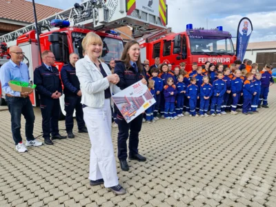 Antje Edelmann von der Land Brandenburg Lotto GmbH (l.) überreichte der Pritzwalker Jugendwehr einen symbolischen Scheck über 700 Euro für den Gewinn beim Videowettbewerb von Lotto und Landesfeuerwehrverband. Foto: Stadt Pritzwalk (Bild vergr&ouml;&szlig;ern)