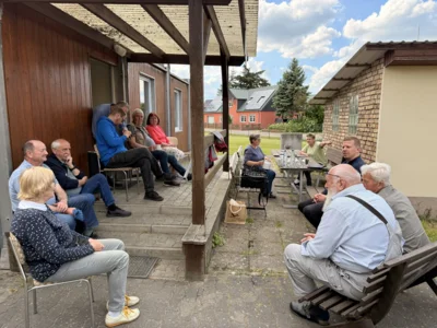 Menschen sitzen bei der Sommertour auf einer Terrasse (Bild vergr&ouml;&szlig;ern)