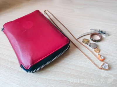 Eine rote Geldbörse mit einigen Schmuckstücken drin liegt im Pritzwalker Fundbüro zur Abholung bereit. Foto: Stadt Pritzwalk (Bild vergr&ouml;&szlig;ern)
