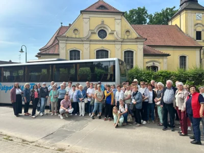 Teilnehmer der Busfahrt vor einem Bus an der Kirche in Köritz (Bild vergr&ouml;&szlig;ern)