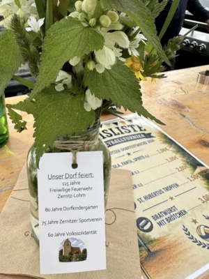 Blumen mit Flyer mit Informationen zu den Veranstaltungen (Bild vergr&ouml;&szlig;ern)