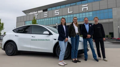 Neues Verwaltungsfahrzeug der Gemeinde Grünheide (Mark), Modell Tesla Y mit v.l. Julia Müller (Leitung Hauptamt), Theresa Eggler (Tesla), Arne Christiani (Bürgermeister), Felix Spiekerkötter (Tesla) Fotonachweis: Tesla Manufacturing Brandenburg SE (Bild vergr&ouml;&szlig;ern)