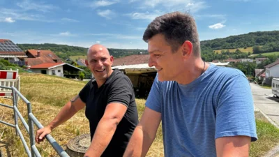 Christian Harig, Leiter der Technischen Werke Mandelbachtal (rechts), und Philipp Weber, Niederlassungsleiter der Aarsleff Rohrsanierung GmbH in Trier, am Regenrückhaltebecken oberhalb der Brudermannstraße. Foto: Stefan Eins, Gemeinde Mandelbachtal.