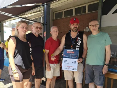 Das Bild zeigt Sina (links) und Christian Kowatzki (2. von rechts) beim gemeinsamen Foto-Termin mit Klaus Keßner, Rüdiger Rothfuchs und Stefan Hoog (von links) während der Drachenboot-Regatta des Ruderclubs Grenzach.