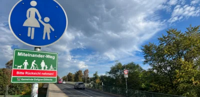 Gehweg- und "Miteinander-Weg"-Schilder an der Brücke an der Wilmsstraße