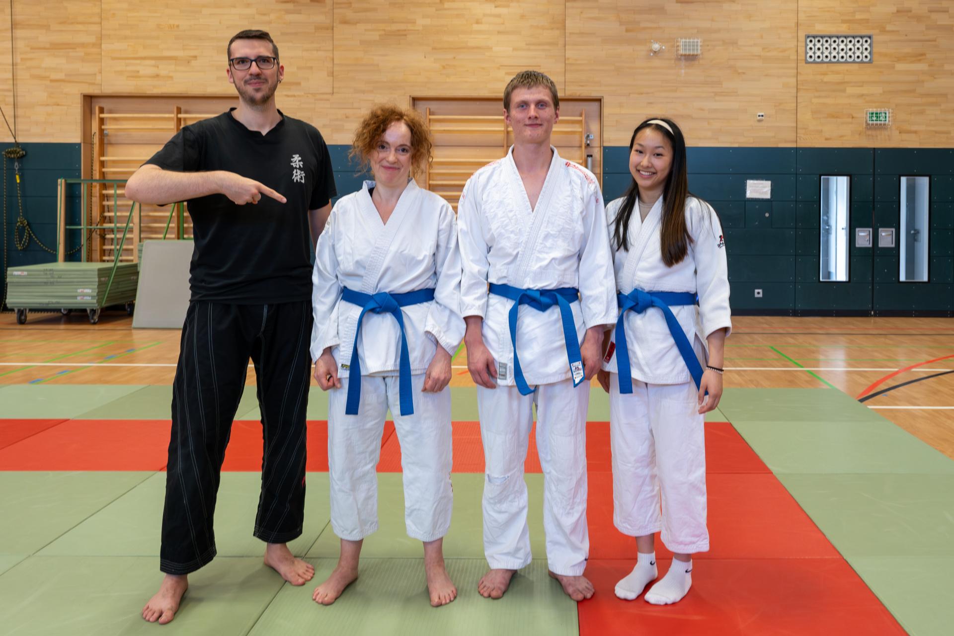 die neuen 'Blaugurte' (v. l. n. r. Alexandra, Leo, Evelyn) mit ihrem Trainer Jerome (ganz links)