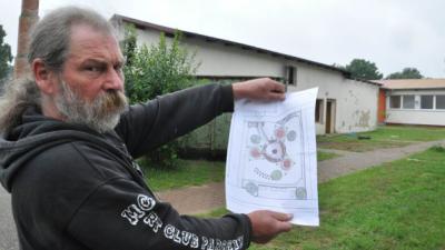 Lothar Barsuhn mit dem Plan für das Grüne Klassenzimmer auf der Baustelle mit dem Abrisshaus.