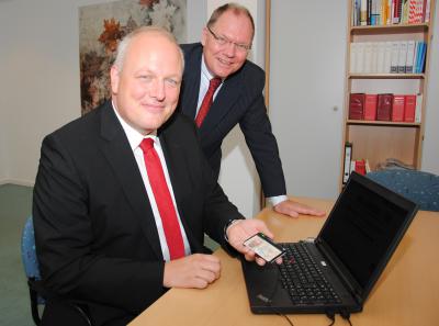 Elektronischer Personalausweis im Einsatz: Der Parlamentarische Staatssekretär Ulrich Kelber (l.) beantragt das erste Führungszeugnis über das neue Internetportal, neben ihm BfJ-Präsident  Heinz-Josef Friehe (Bild vergr&ouml;&szlig;ern)