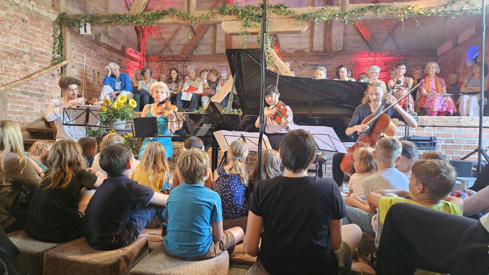 Zahlreiche Kinder waren zum Familienkonzert gekommen und hatten auf Matten direkt vor den Musikern Platz genommen. Foto: Dörthe Ziemer