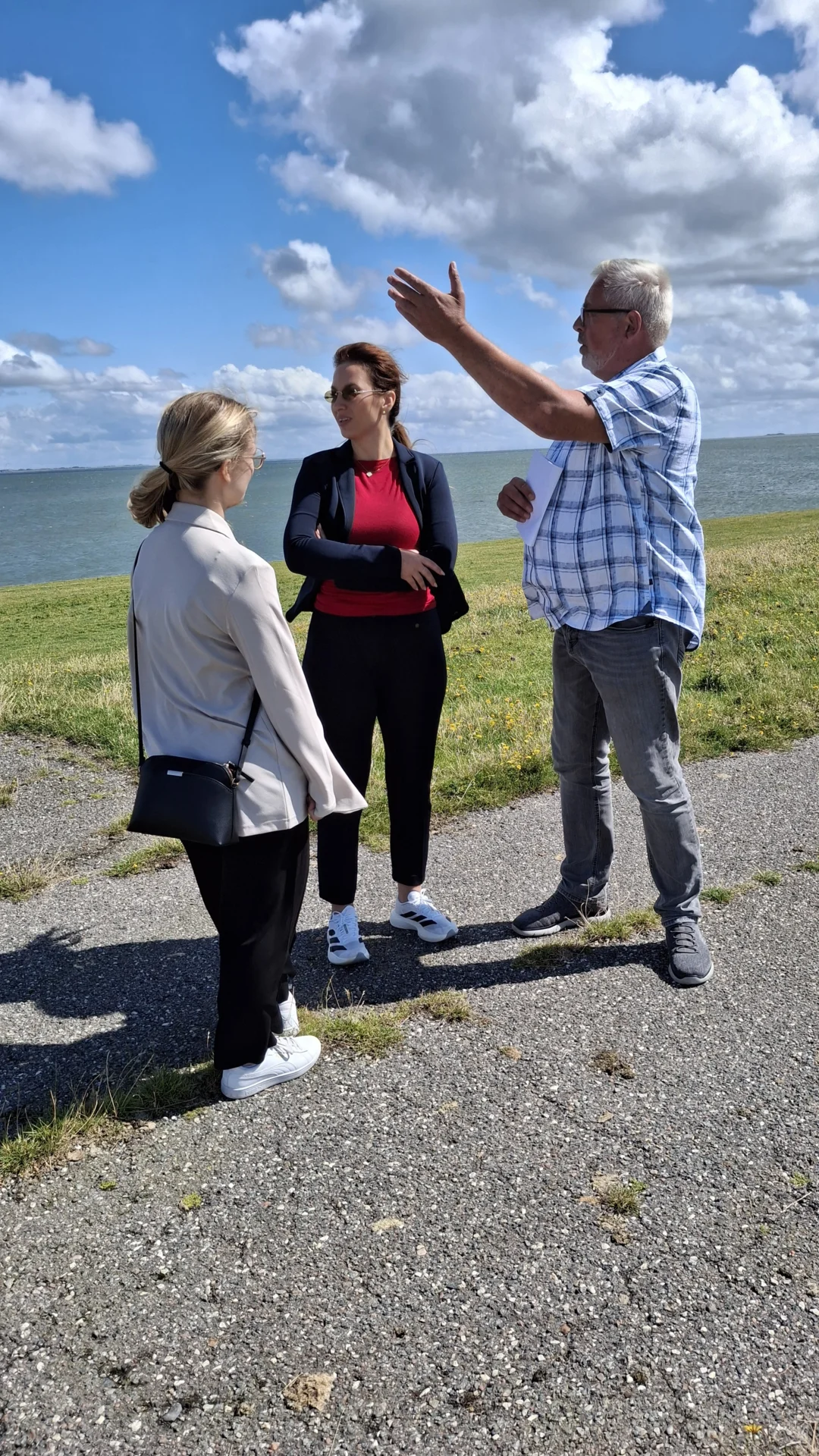 Oevenums Bürgermeister Hauke Brodersen zeigt Ministerin Finke und ihrer persönlichen Referentin Luca Hansen die vielen Windräder auf dem Festland (Foto: AmtFA Andreas Hansen)