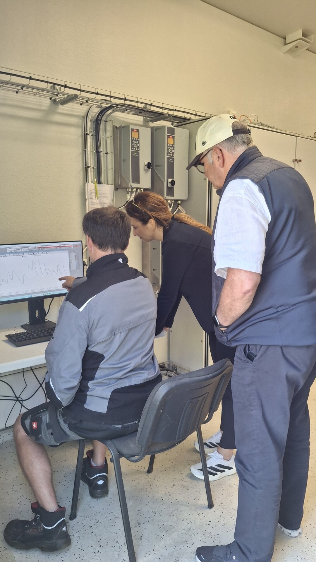 Stolz zeigen Oldsums Bürgermeister Hark Riewerts (mit weißer Mütze) und Vorstand Brar Hinrichsen (mit grauer Jacke) der Ministerin das neue insulare Kraftwerk (Foto: AmtFA Andreas Hansen)
