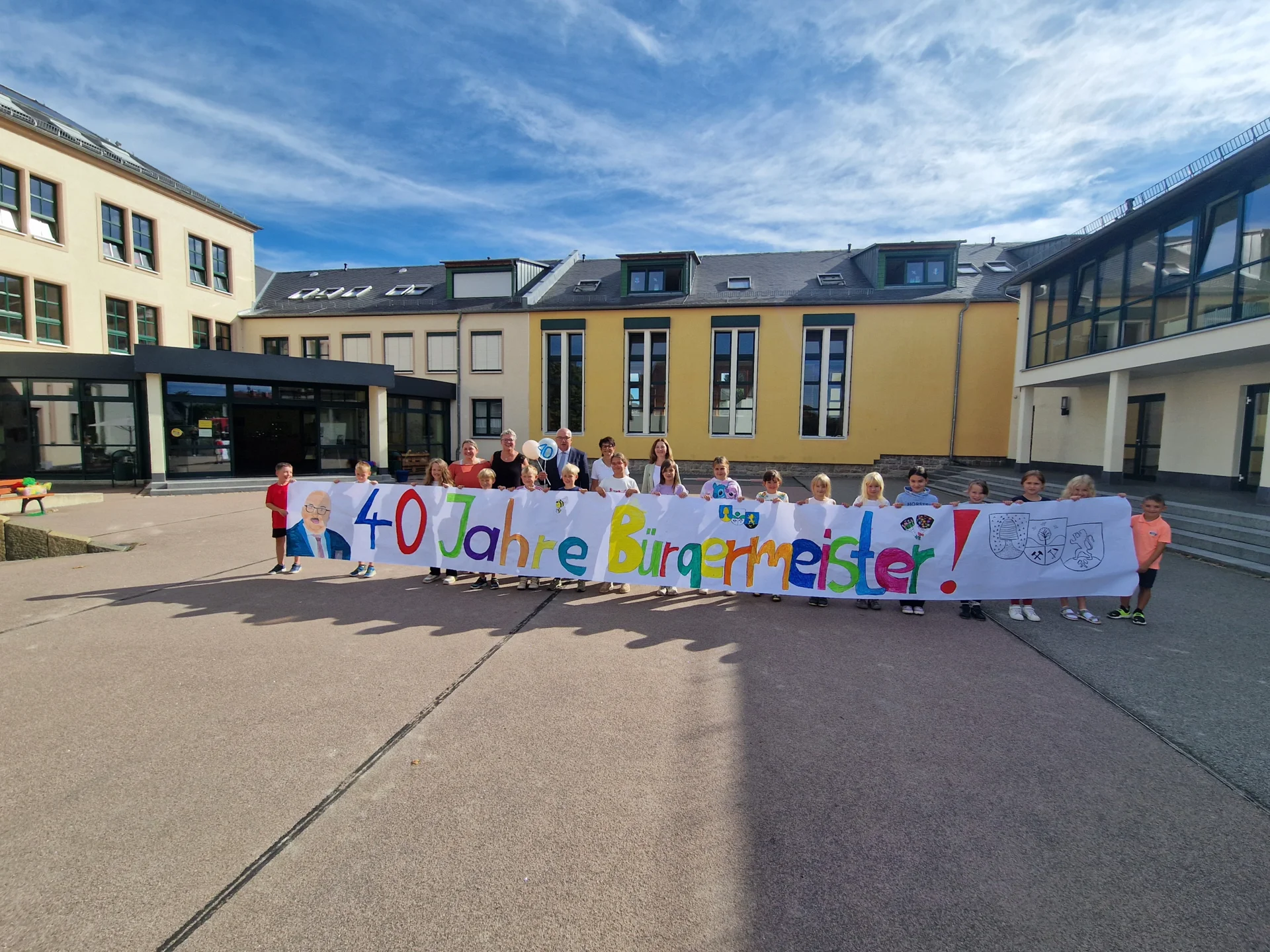 Kinder und Schüler mit ihrem Erzieher- und Lehrerkollegium