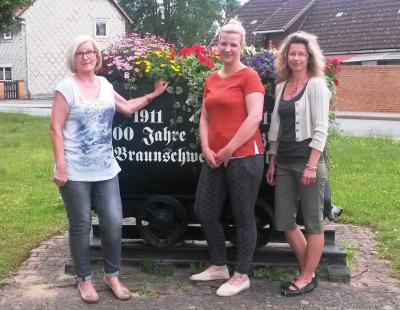 Die Inhaberin der Blumenstube Tina Schräder (Mitte) mit ihren Mitarbeiterinnen Veronika Tietz (l.) und Claudia Hartmann (r.) vor einer der bepflanzten Loren.