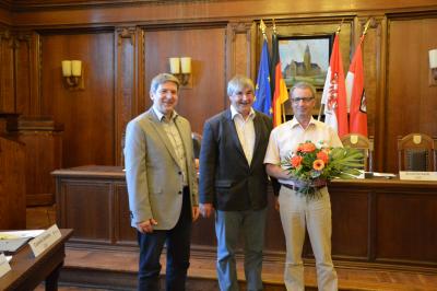 Karsten Korup (m.) und Bürgermeister Oliver Hermann überreichten Blumen an Hans-Jürgen Döllefeld. I Foto: Christiane Schomaker