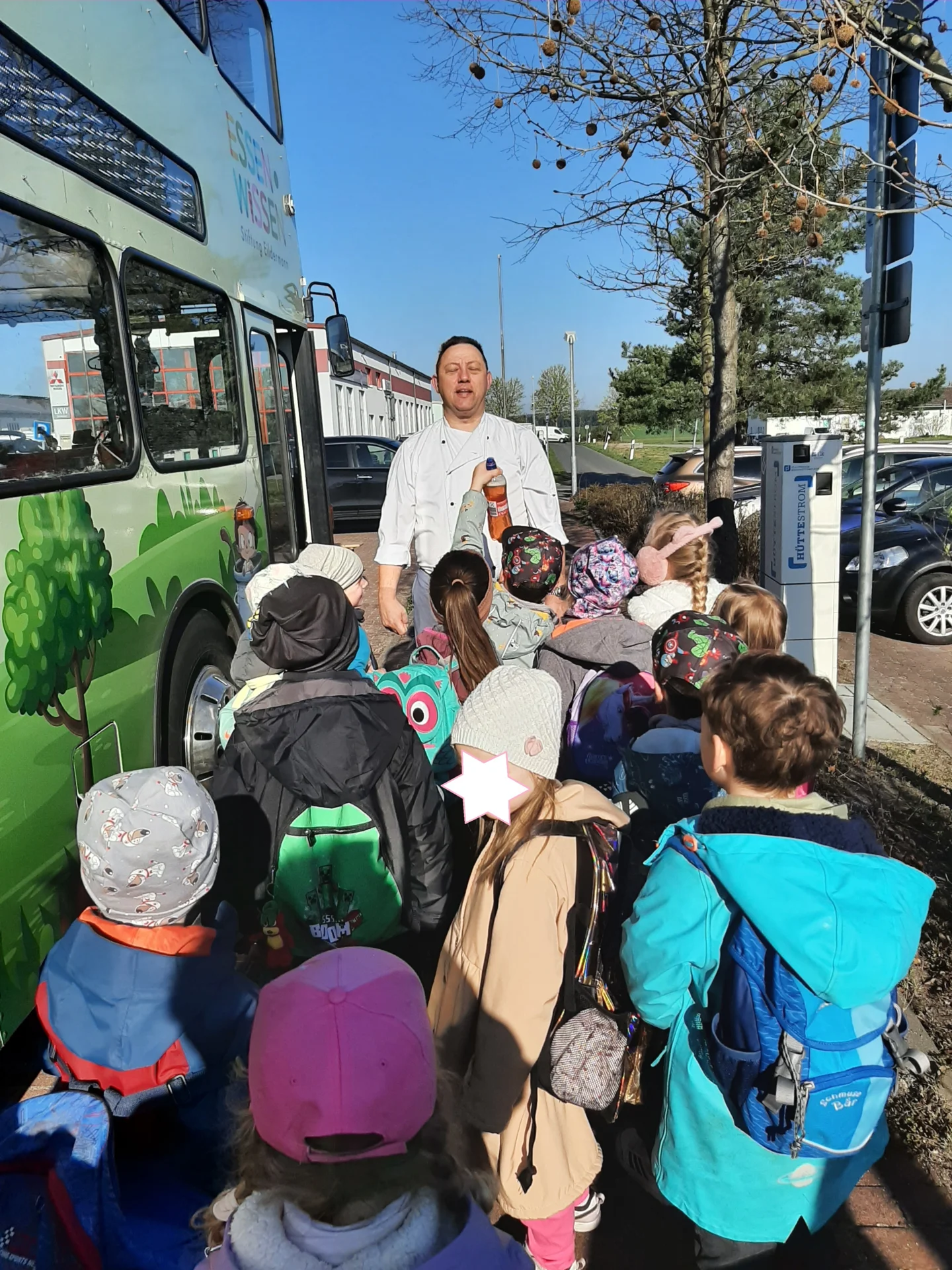 Aufgeregte Kinder vor den Türen des Koch-Busses