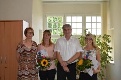 Bürgermeister Heiko Müller gratuliert den beiden ehemaligen Auszubildenden Mandy Denkert (2. v. l.) und Julia Meier (r.) zum erfolgreichen Abschluss im Beisein der Fachbereichsleiterin Personal Renate Gresens.